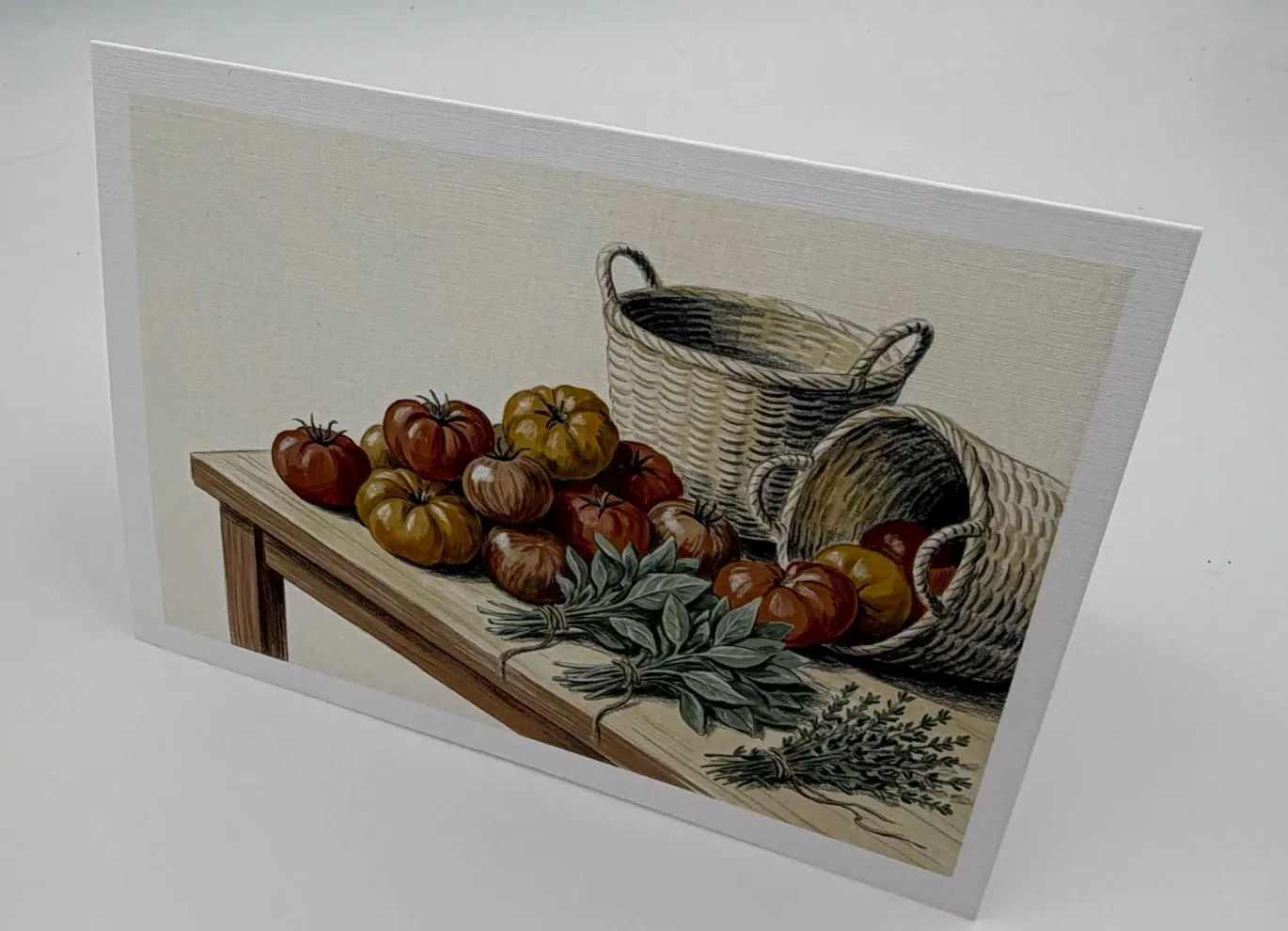 Photo of the printed card front: heirloom tomatoes, herbs and baskets on a wooden table