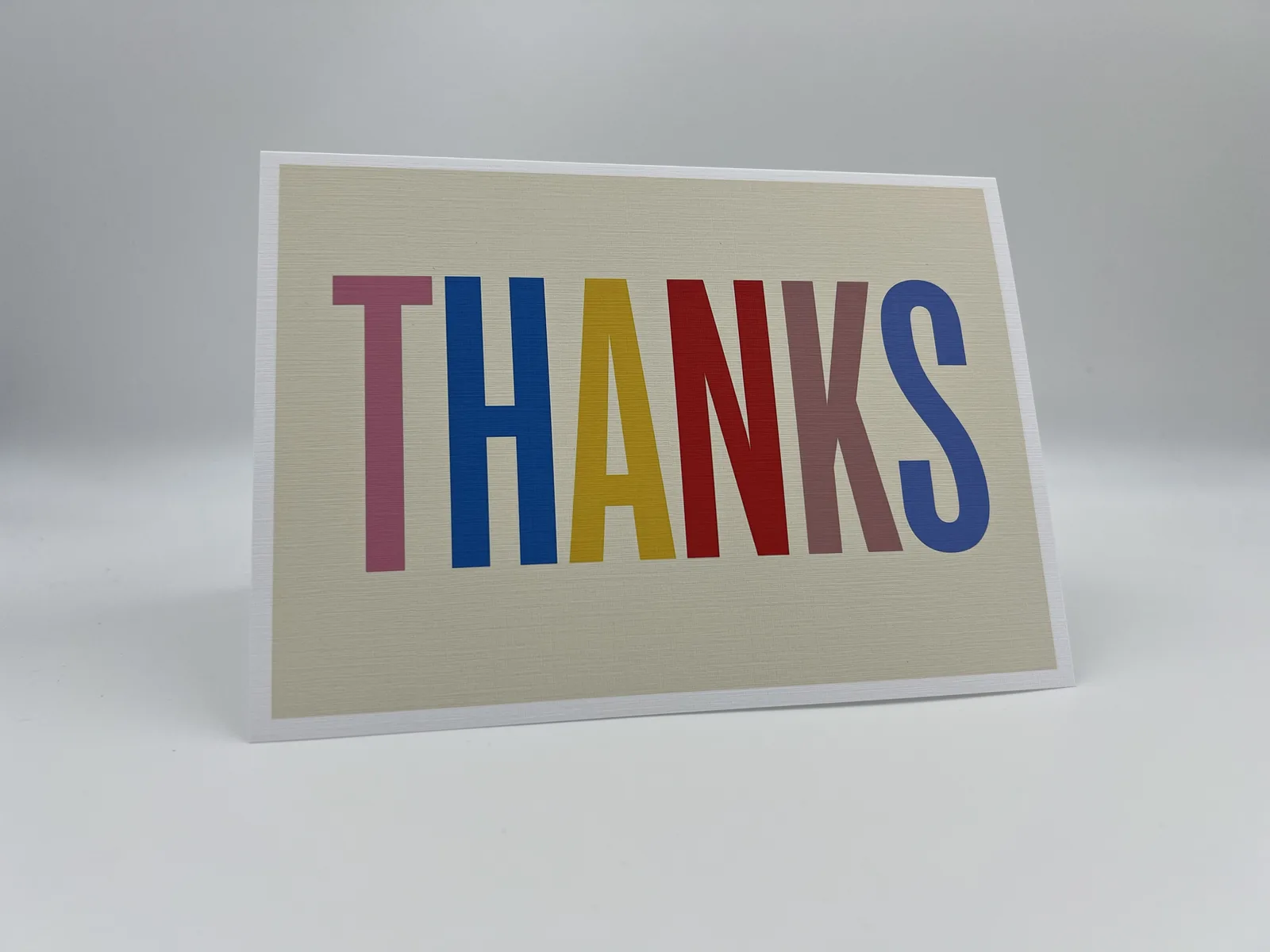 A folded thank-you card with THANKS in multicoloured block letters
