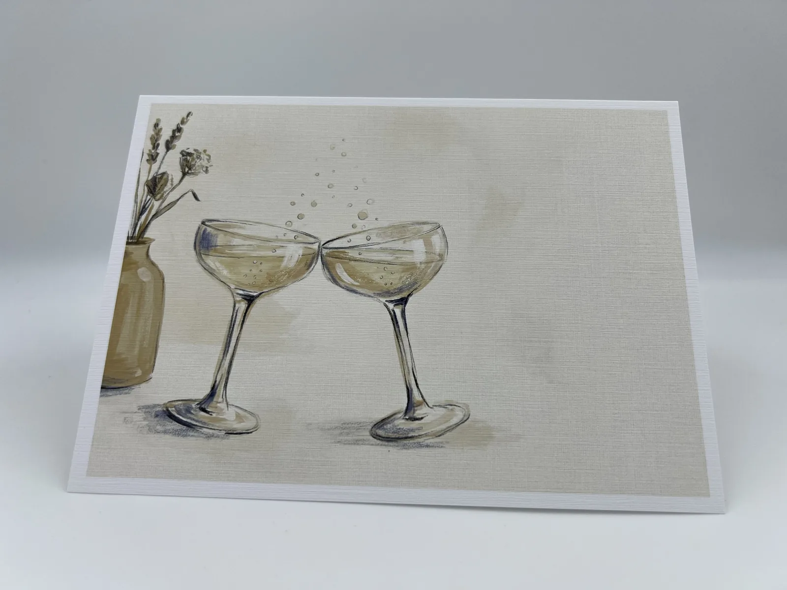 A wedding thank-you card illustrated with two champagne coupes clinking in a toast